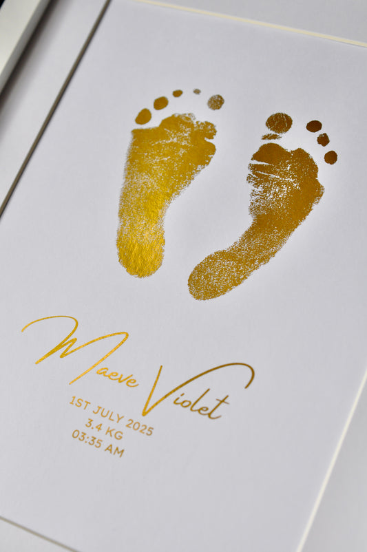 Gold footprints on a white card with baby details