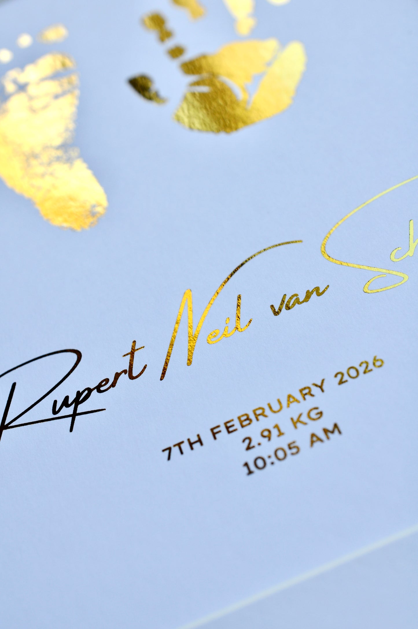 Baby birth details with gold text on a white background