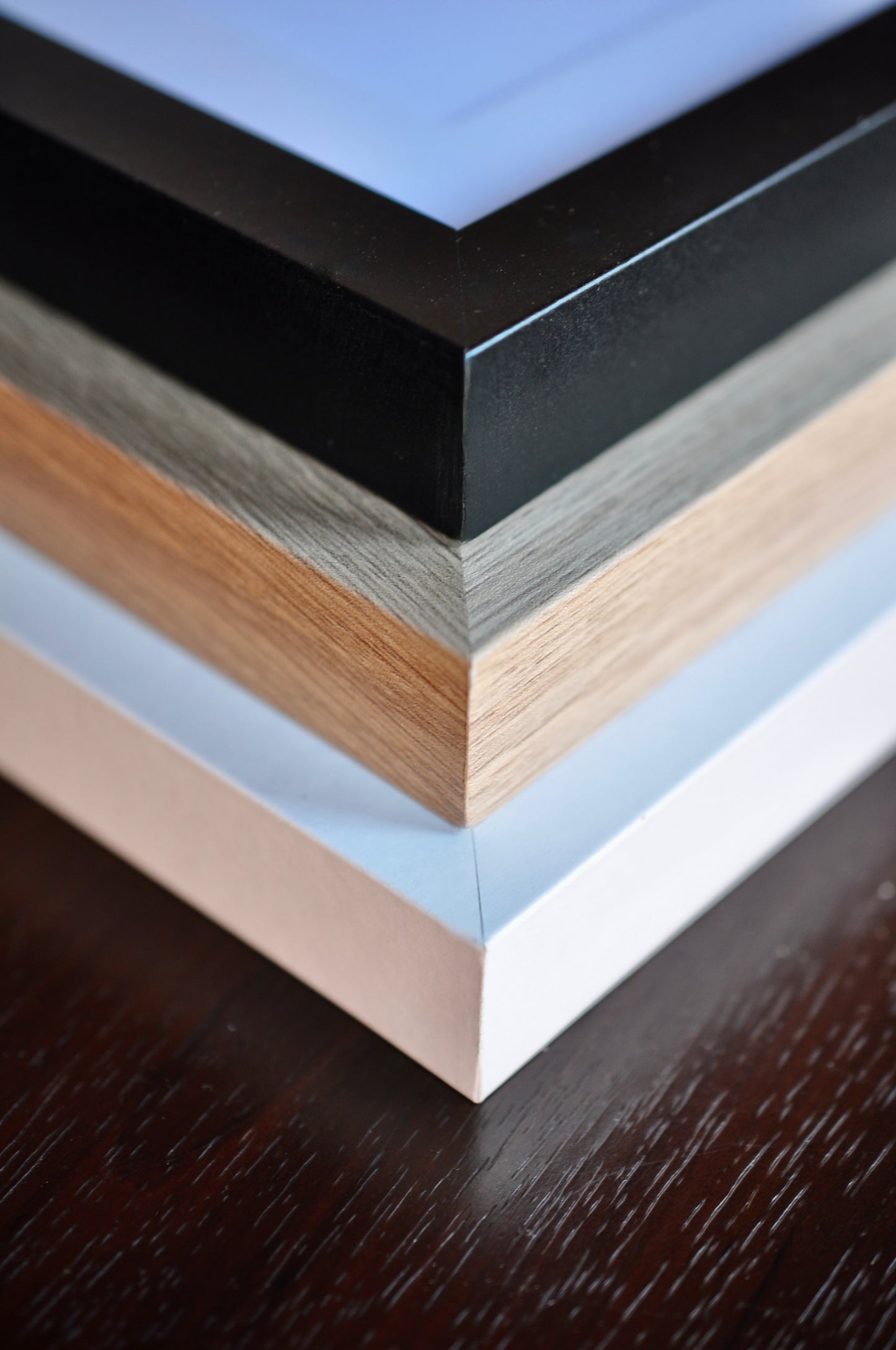 Collection of different colored picture frames on a wooden surface