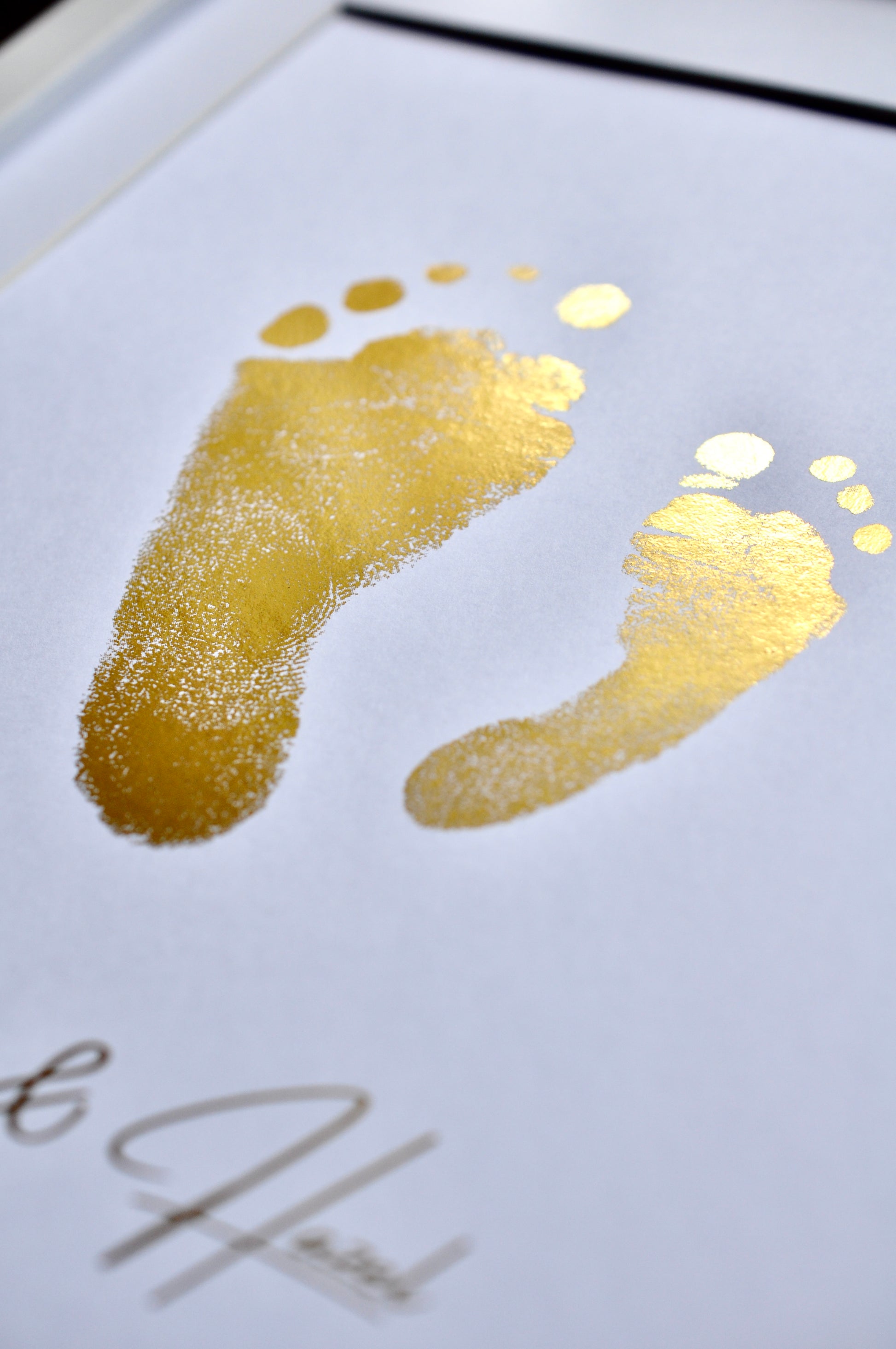 Gold footprints on a white card with 'John' and 'Helen' written below.