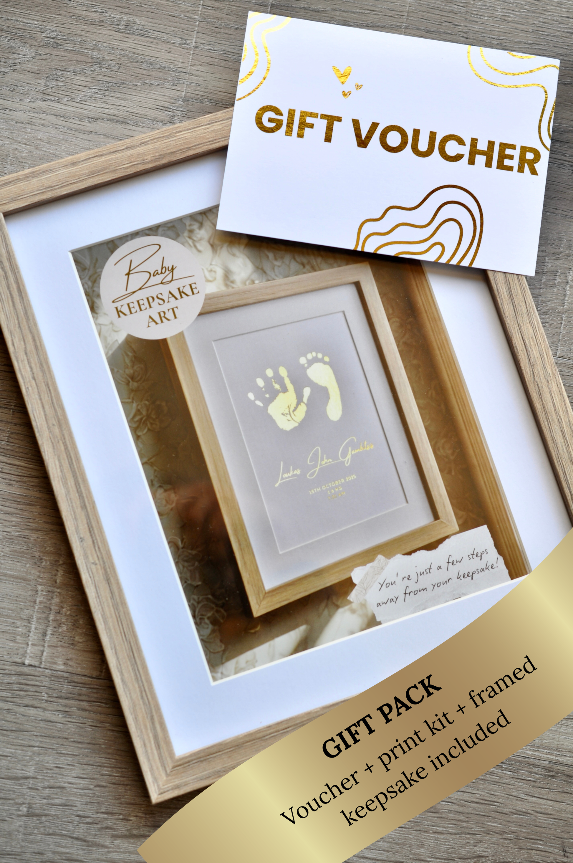 Gift pack with framed baby keepsake art and gift voucher on a wooden surface