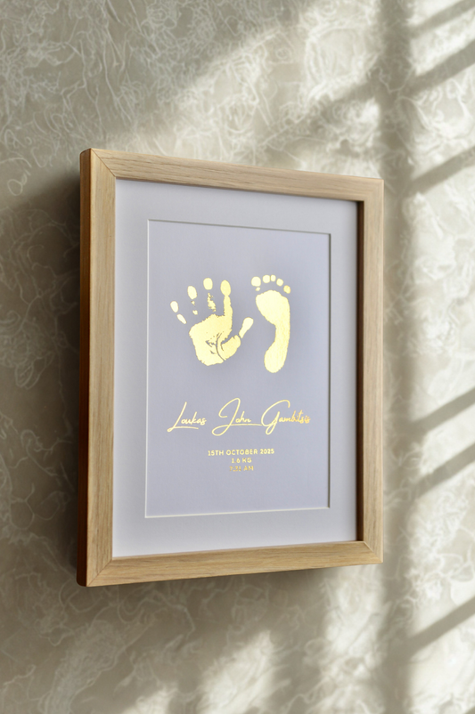 Framed artwork with baby hand and footprints on a textured wall