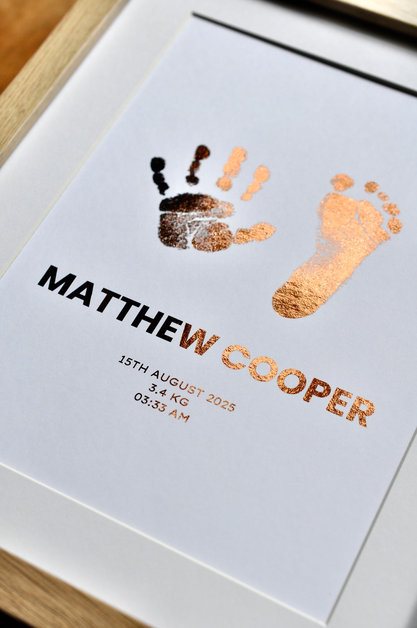 Baby keepsake with hand and footprints and personalized text on a white background.
