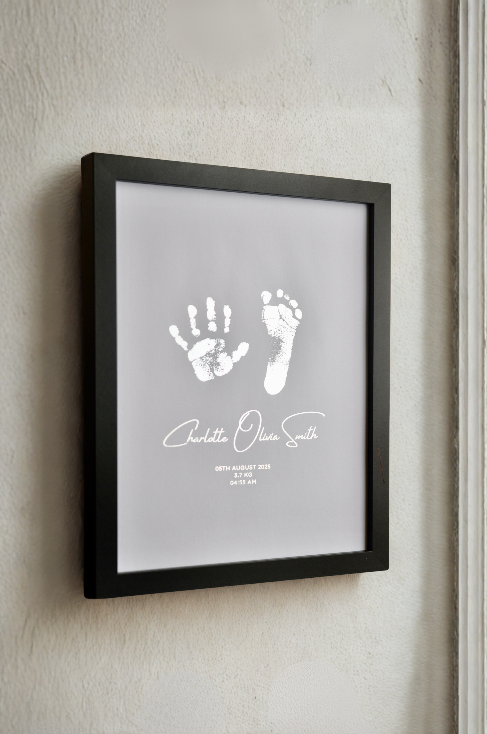 Framed print with hand and footprints on a wall