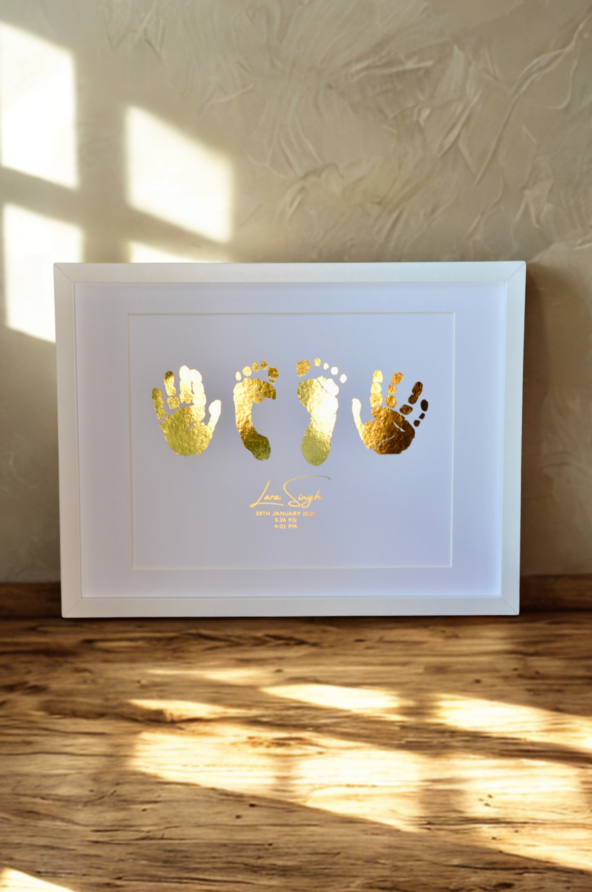 Baby Keepsake with and and feet on white background in a white frame