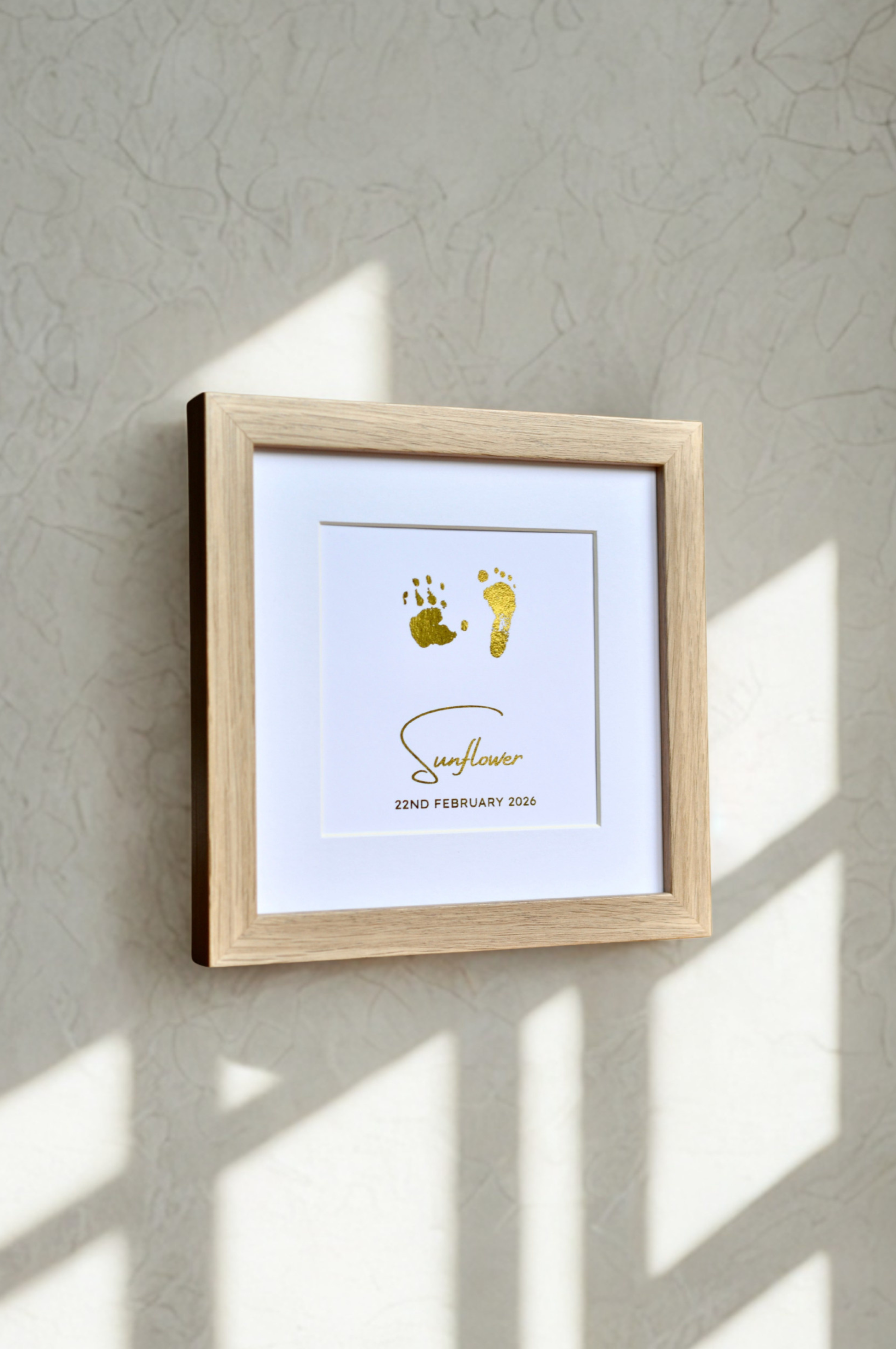 Framed artwork with footprints and text on a textured wall