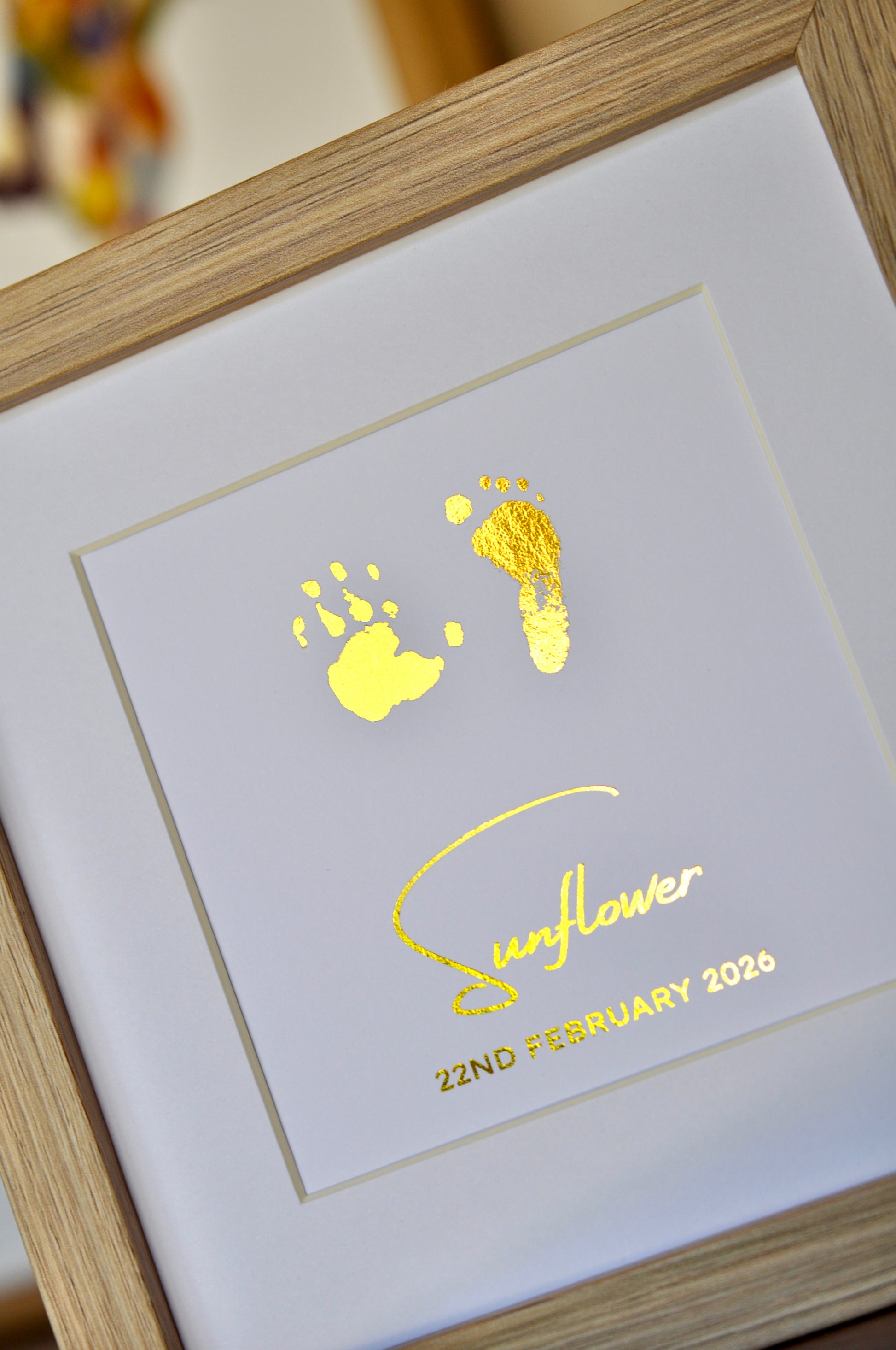 Framed keepsake with gold baby footprints and 'Sunflower 22nd February 2026' text.