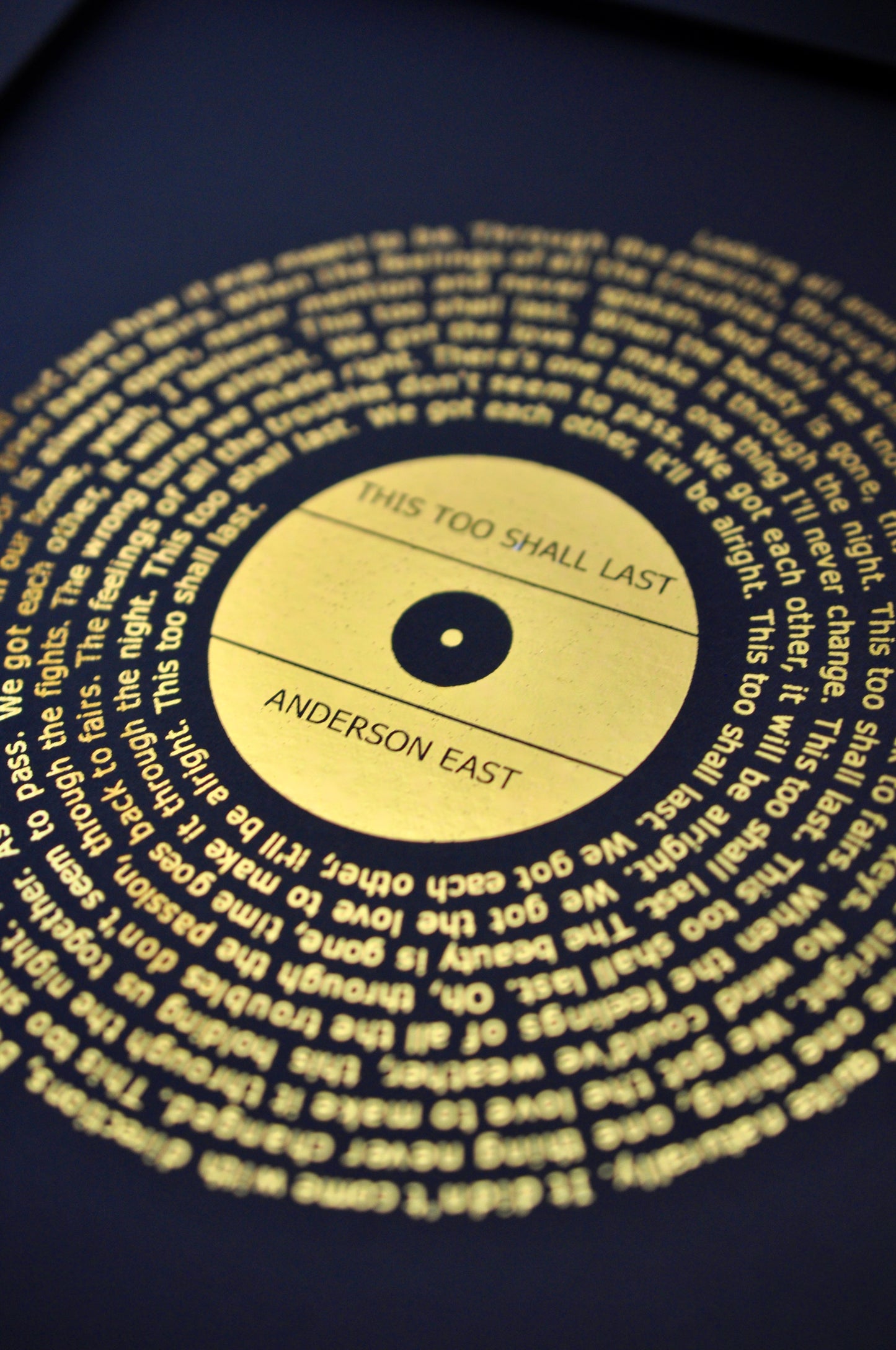 Gold song lyrics print on a black background