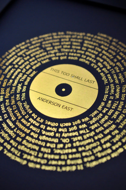 Gold song lyrics print on a black background
