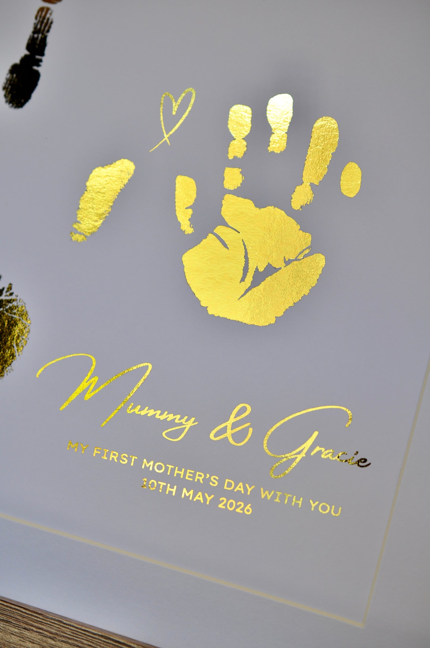 Handmade card with gold handprints and 'Mummy & Gracie' text on a white background