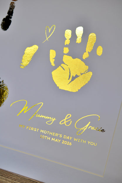 Handmade card with gold handprints and 'Mummy & Gracie' text on a white background