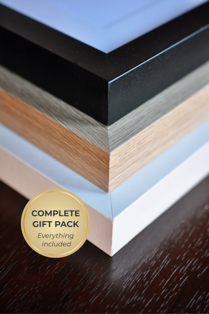 Collection of wooden frames with a 'Complete Gift Pack' label on a dark surface
