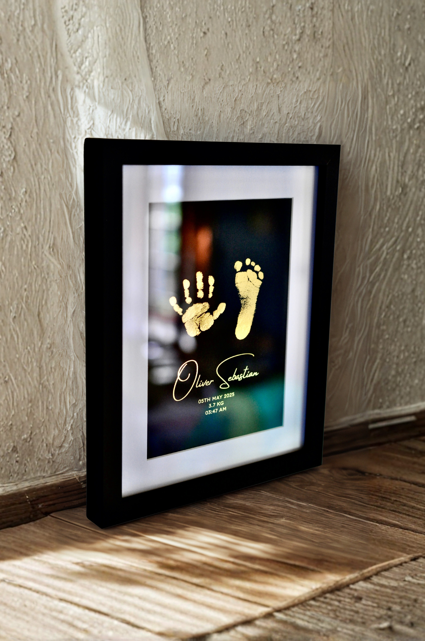 Framed artwork with hand and footprints on a textured wall.