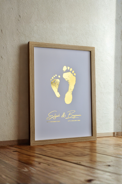Framed print with gold footprints and text on a light background