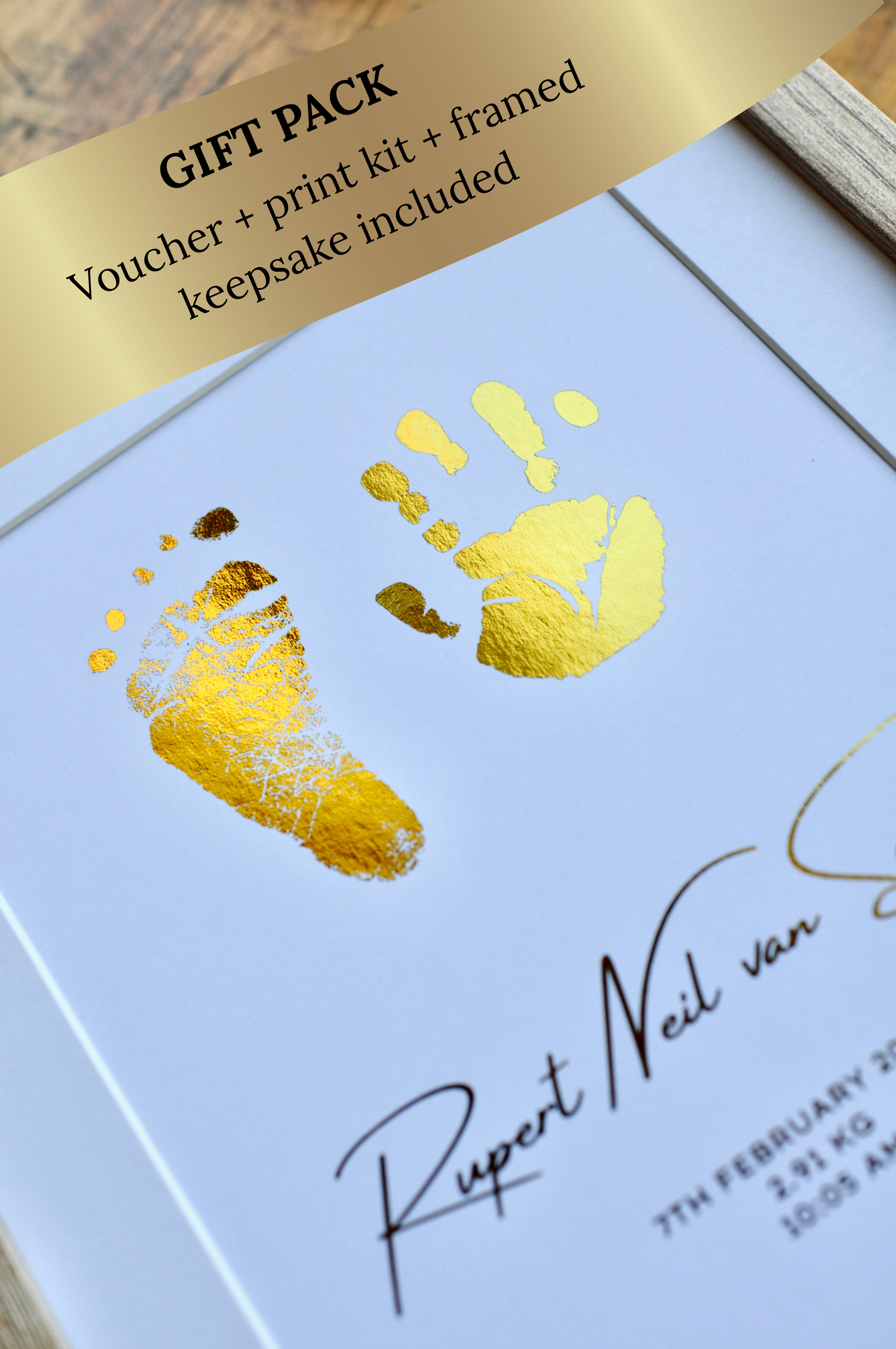 Gift pack with gold hand and footprints on a white card, featuring a voucher and print kit.
