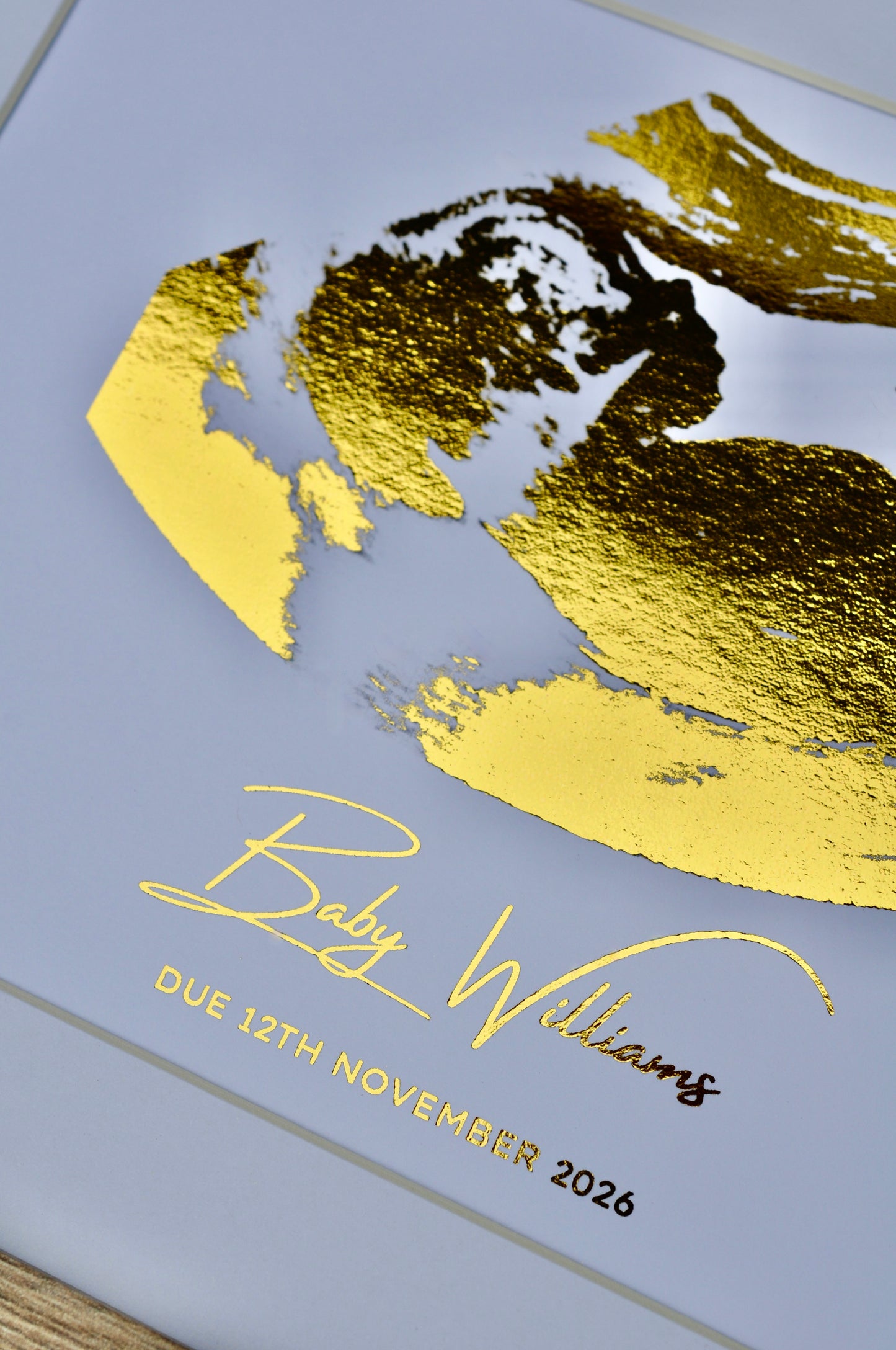 Gold foil baby ultrasound with silhouette of a baby, name and due date  on white background