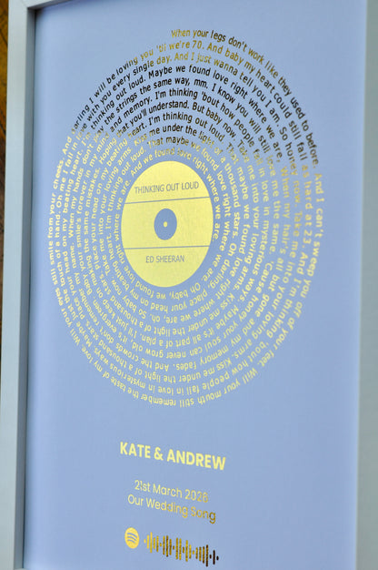 Personalized framed artwork with text and a golden song lyrics circle, featuring 'Kate & Andrew' and a date.