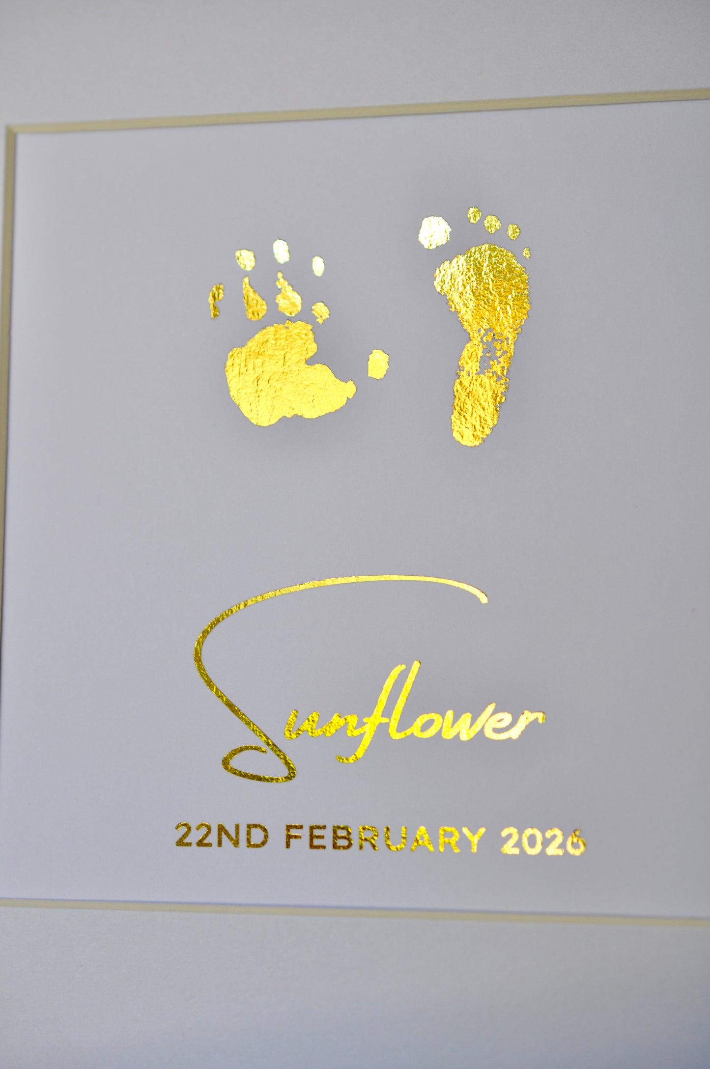 Decorative card with gold footprints and 'Sunflower 22nd February 2020' text on a white background