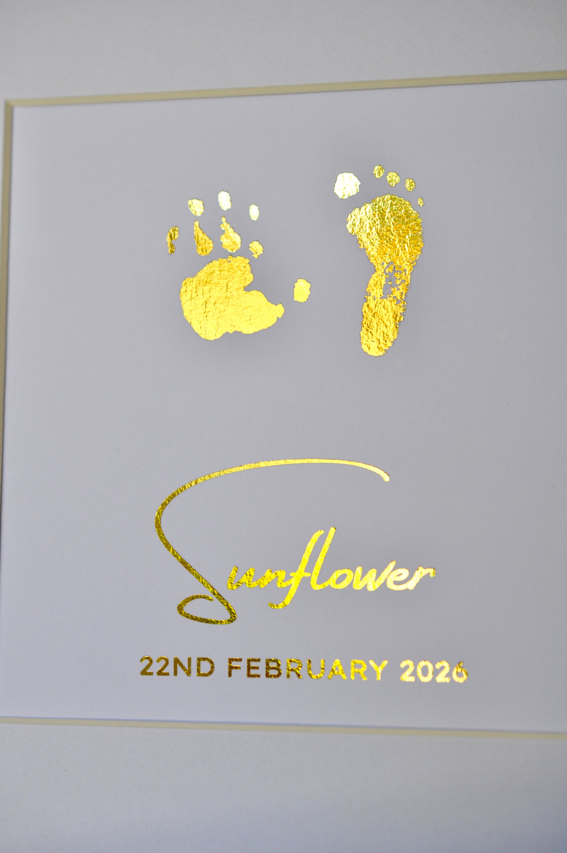Decorative card with gold footprints and 'Sunflower 22nd February 2020' text on a white background