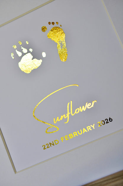 Gold foil baby footprints and handprints on a card with 'Sunflower' and '22nd February 2026' text.