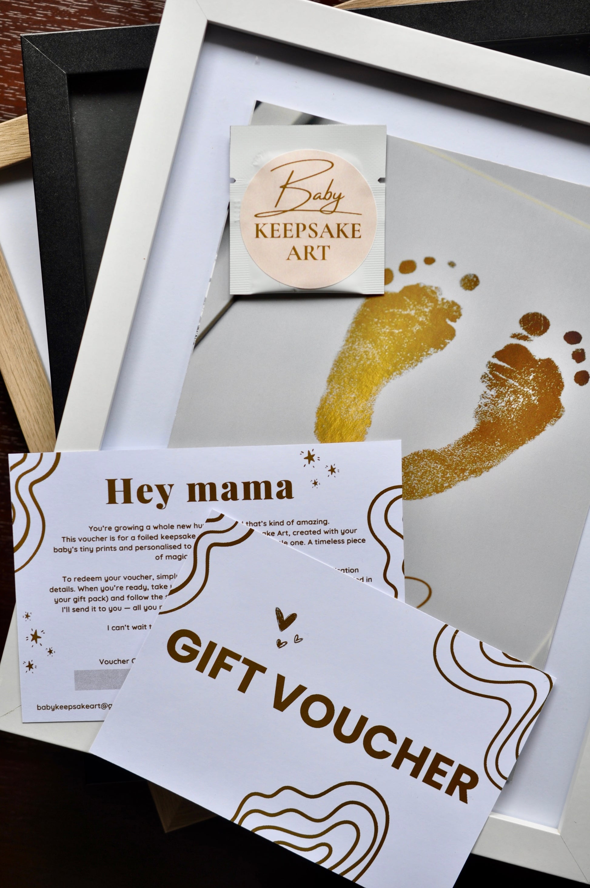 Gift voucher for baby keepsake art with gold footprints and 'Hey mama' card.