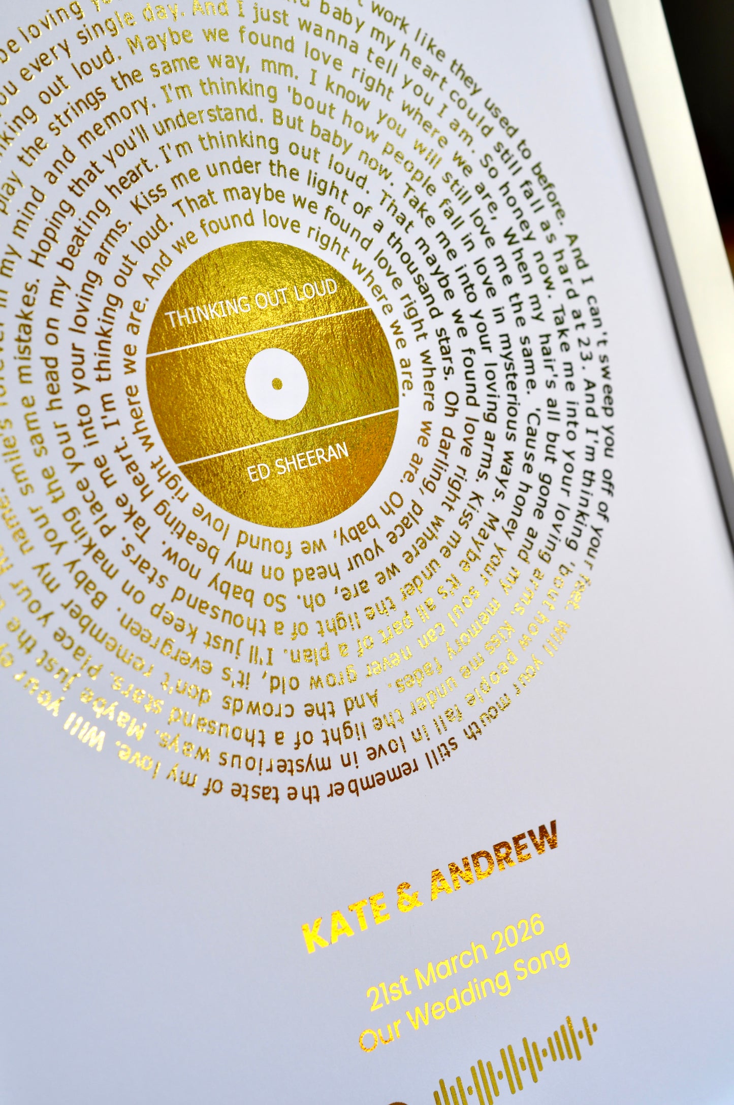 Personalized wedding album with gold text and a gold disc on a white background