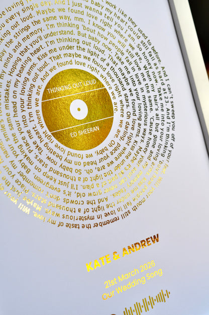 Personalized wedding album with gold text and a gold disc on a white background